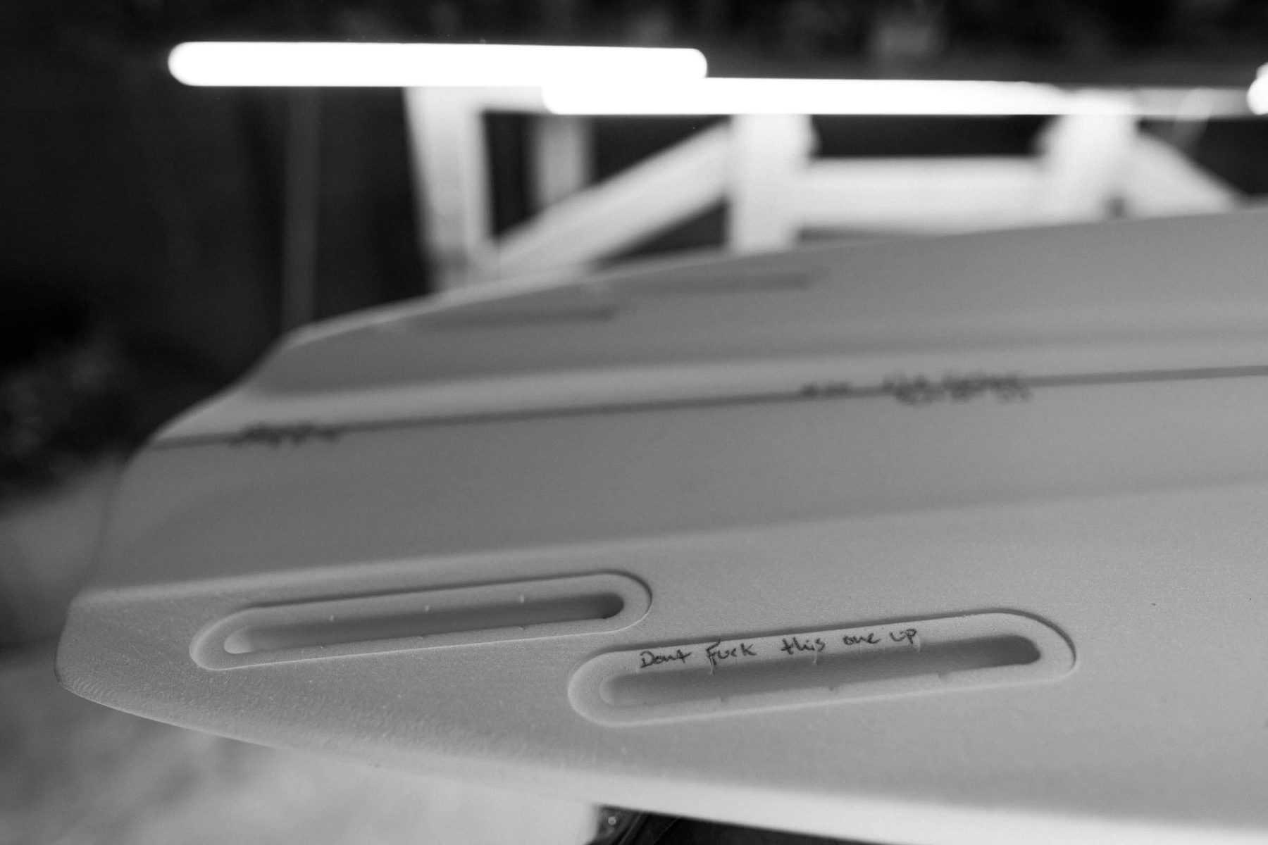 Hand-shaping a surfboard at Lazy Robot